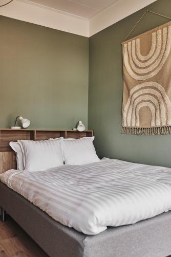 a bedroom with a bed with a painting on the wall at Hotell Slottsgatan in Oskarshamn