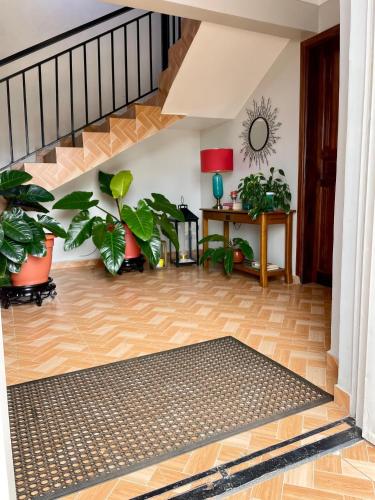 a living room with plants and a staircase at 8693 Abba Place in Kampala