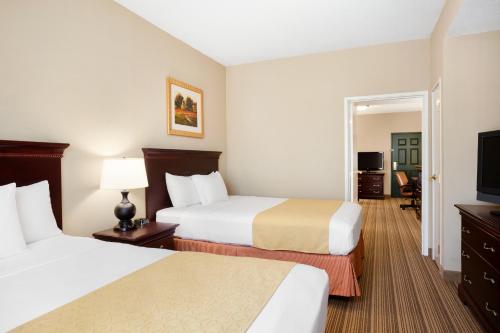a hotel room with two beds and a flat screen tv at Country Inn & Suites by Radisson, Ithaca, NY in Ithaca