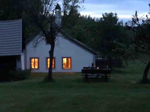 a man sitting on a bench in front of a house at Forsthartl 7 Landhausurlaub in Steinbach