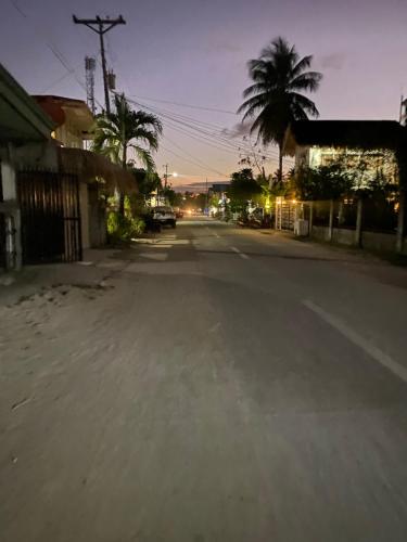 an empty street with palm trees in a town at Isla Casita Homestay Siargao in General Luna