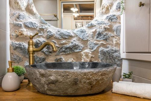 a bathroom with a large stone tub and a sink at Terra Creta Hideaway in Heraklio Town