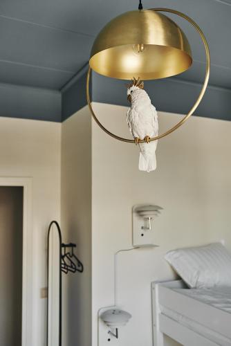 un pájaro en una lámpara de araña en un dormitorio en Hotell Slottsgatan, en Oskarshamn
