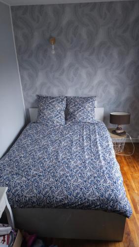 um quarto com uma cama com um edredão azul em Au Bois Fleuri em Bracieux