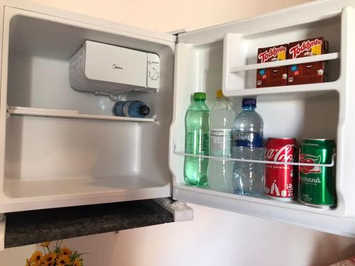 an open refrigerator filled with drinks and soda at Cantinho da mery 1 in Maragogi