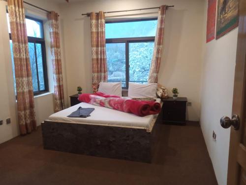 a bedroom with a bed with a large window at Hunza Hilton Hotel Gilget Baltestan in Gilgit