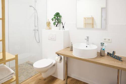 a white bathroom with a toilet and a sink at IDEE Living: Modernes City-Apartment mit Altbaucharme in Weinheim