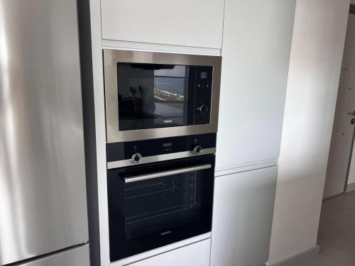 a kitchen with a microwave and a stove at Ulu Panorama Residence in Alanya