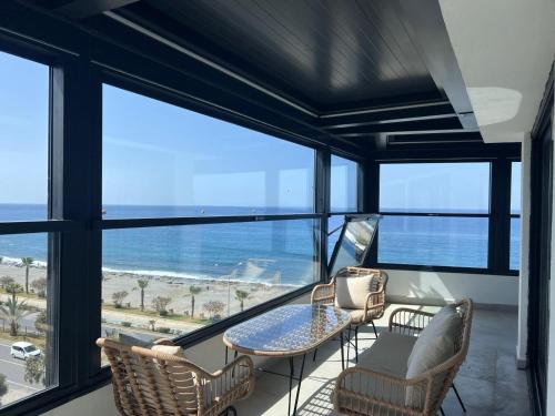 a room with a table and chairs and a view of the ocean at Ulu Panorama Residence in Alanya