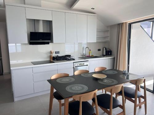 a kitchen with a black table and chairs in a kitchen at Ulu Panorama Residence in Alanya