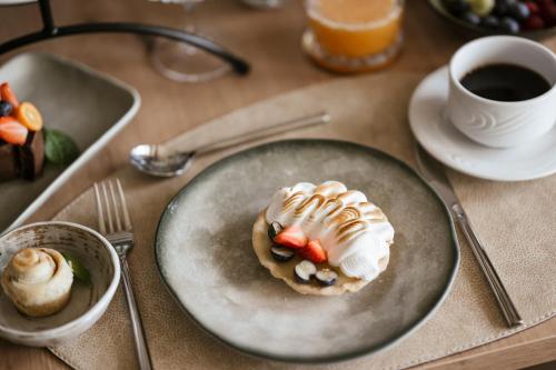 a plate with a dessert on a table with a cup of coffee at Boutique Hotel Wiesenhof - Adults Only in Lana