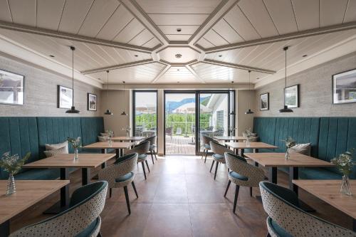 a dining room with wooden tables and chairs at Boutique Hotel Wiesenhof - Adults Only in Lana