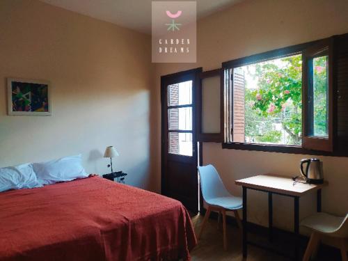 1 dormitorio con 1 cama, 2 sillas y ventana en Garden dream en San Salvador de Jujuy