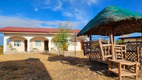 a building with a large umbrella and chairs in front of it at Mangoverde Guesthouse in Moalboal