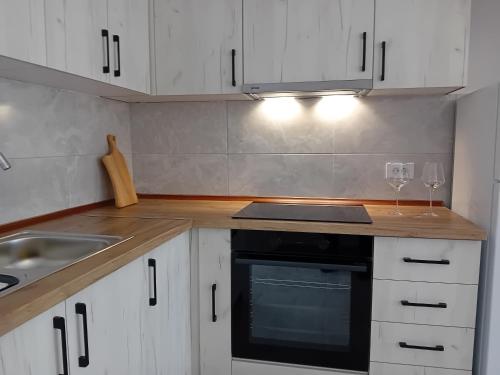 a kitchen with white cabinets and a sink and a stove at Apartment Kalin in Gevgelija