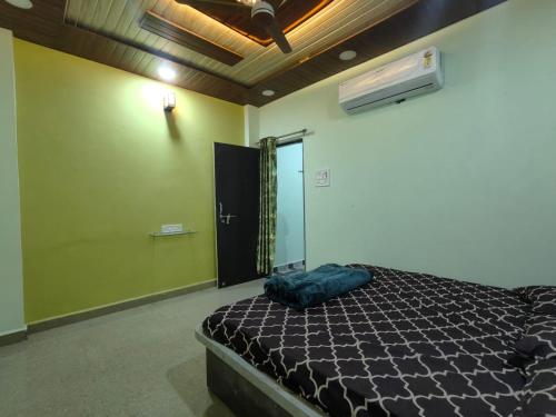 a bedroom with a bed in a room with a fan at Mahakal Homestay in Ujjain