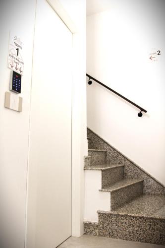 a staircase in a house with white walls and concrete stairs at Ophelia - luxury house in Ioppolo Giancaxio