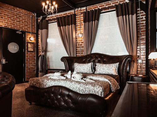 a bedroom with a leather bed with two dogs laying on it at Letana Hotel in Bang Phli