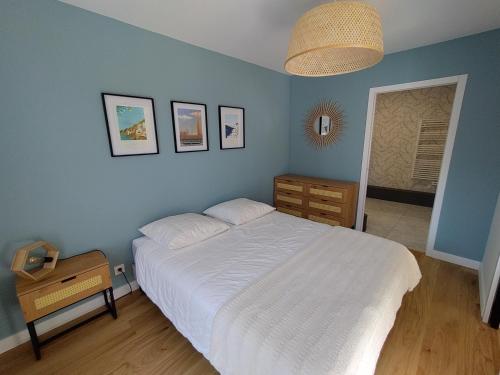 - une chambre avec un lit blanc et un mur bleu dans l'établissement Évasion en bord de mer - 350m plage - Garage privé, à Concarneau