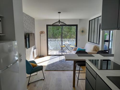 une cuisine et un salon avec une table et des chaises dans l'établissement Évasion en bord de mer - 350m plage - Garage privé, à Concarneau