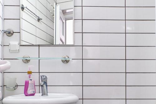 La salle de bains blanche est pourvue d'un lavabo et d'un miroir. dans l'établissement CARETTA PANSİYOn, à Kaş