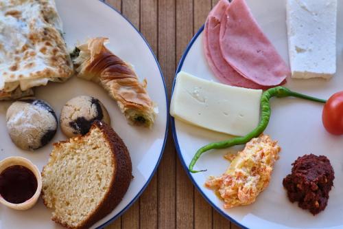 zwei Teller mit verschiedenen Arten von Lebensmitteln auf einem Tisch in der Unterkunft CARETTA PANSİYOn in Kaş