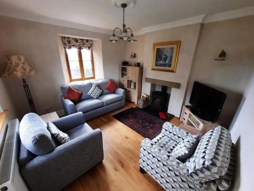 a living room with two couches and a television at Former school cottage near Bridgnorth in Bridgnorth