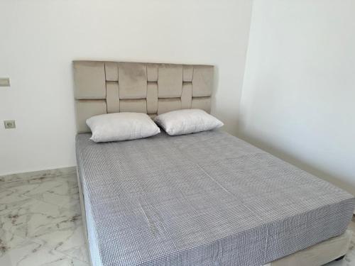 un lit avec deux oreillers dessus dans une chambre dans l'établissement Modern beach appartment in the heart of Martil, à Martil