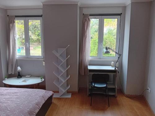 sypialnia z biurkiem, łóżkiem i oknami w obiekcie Sunny Two Bedroom Apartment w Lizbonie