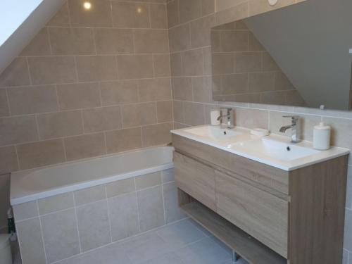 a bathroom with a sink and a bath tub at Le palmier nantais in Mouzeil