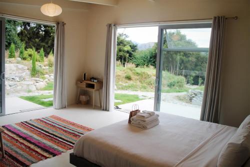 a bedroom with a bed and a large sliding glass door at The Hidden Spring in Wanaka