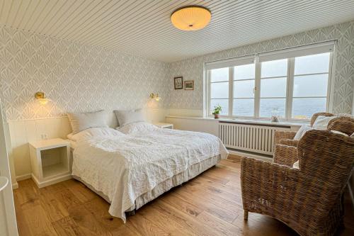 a bedroom with a bed and a window and a chair at Stammershalle Badehotel in Bådsted
