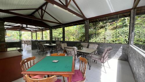a restaurant with a green table and chairs at Casa Mara in Nova Friburgo