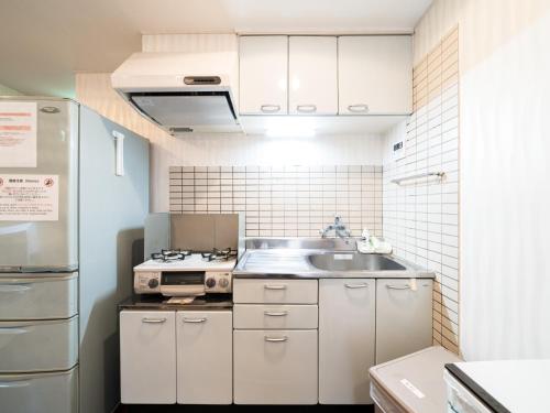 a small kitchen with a sink and a refrigerator at Shinjuku Area, Kagurazaka 1min walk, 80sqm,Family Friendly,Free Wi-Fi, PocketWi-Fi in Tokyo