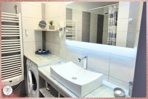 une salle de bain avec un lavabo blanc et un miroir dans l'établissement La Palmeraie, maison 6pers en résidence avec piscine à 300m des plages de Valras-Plage, à Valras-Plage