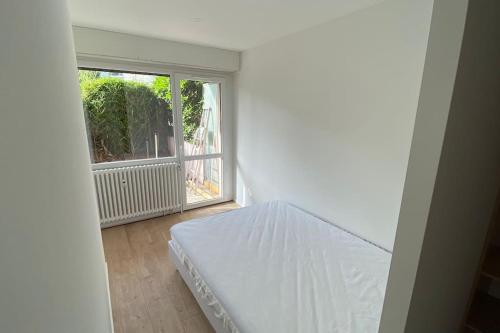 un lit blanc dans une chambre avec une fenêtre dans l'établissement « Le scandinave » T2 wifi, terrasse et parking, à Thonon-les-Bains