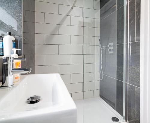 a bathroom with a white sink and a shower at Gorgeous Loft Room in Beckenham