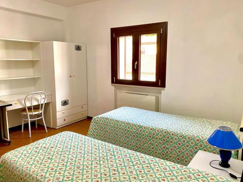 a bedroom with two beds and a window and a desk at La mia casa sul Pollino in San Lorenzo Bellizzi