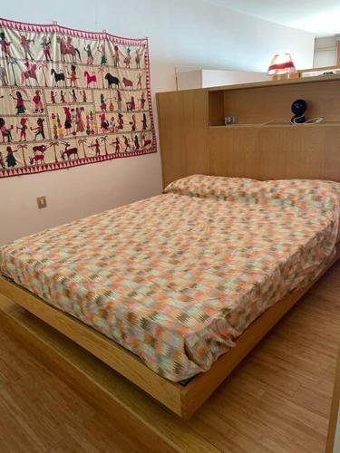 a bed in a bedroom with a blanket on it at Alloggio a picco sul mare in Grimaldi