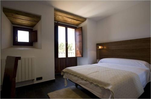 a bedroom with a white bed and a window at Hospederia Convento San Francisco in Santo Domingo de Silos