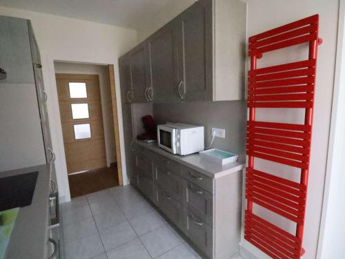 une cuisine avec un four micro-ondes au-dessus d'un comptoir dans l'établissement Appartement familial en hyper centre de Royan, 6/8 pers, ascenseur - FR-1-494-180, à Royan