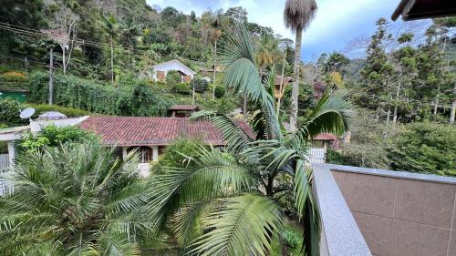 a house with palm trees in front of a mountain at Casa Mara in Nova Friburgo