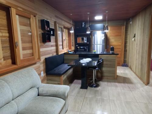 a kitchen with a couch and a table in a room at Pousada Encantos Da Montanha in Louro Müller