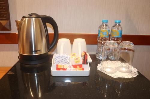 a coffee pot sitting on a table with a tray of food at GSS Avenue Hotel Ex Delmon Hotel in Dubai