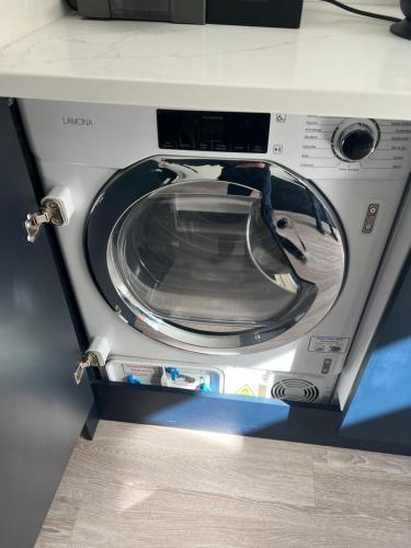 a washing machine with its door open on a counter at Mode Apartments St Annes in Lytham St Annes