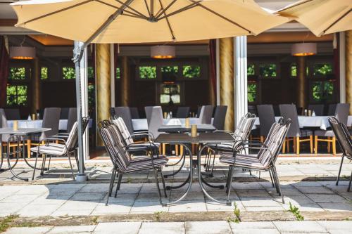 a group of chairs and tables with umbrellas at Schlossgasthof Rösch in Blaibach