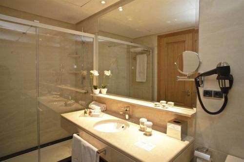 a bathroom with a sink and a shower with a mirror at ArtPlatinum SUITES&APARTMENTS in Benalmádena