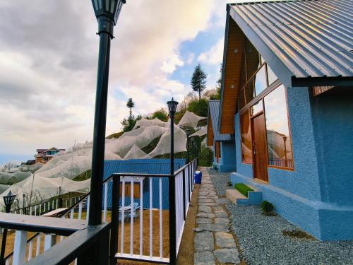 ein blaues Haus mit Straßenlicht neben einem Gebäude in der Unterkunft Snowind Cottages in Kūfrī