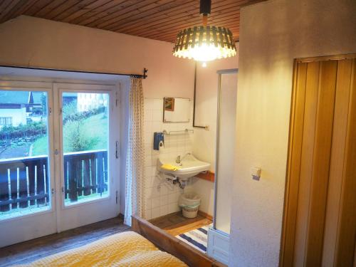 baño con lavabo junto a un balcón en Gasthof zur Post, en Sankt Lorenzen im Lesachtal