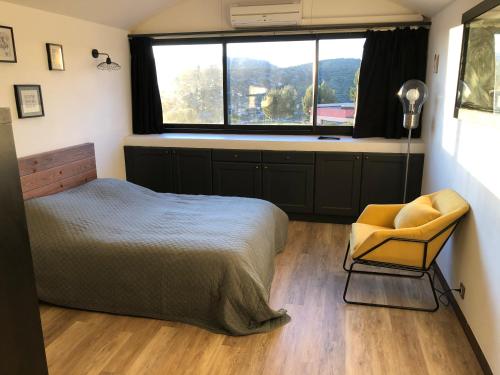 een slaapkamer met een bed, een stoel en een raam bij Studio 29 Cassis in Cassis